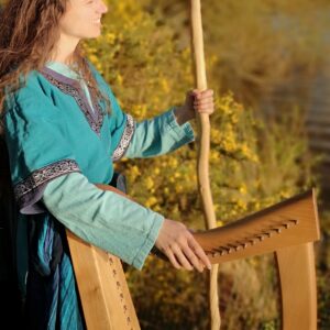 Morgan en tenue de Barde, sa harpe à la main, au coeur de la forêt de Brocéliande