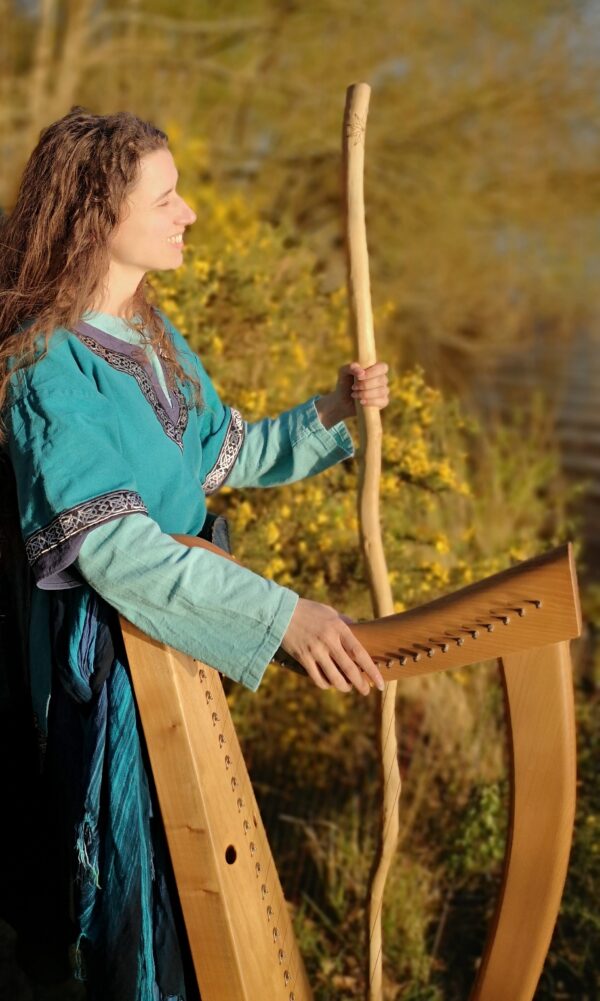 Morgan en tenue de Barde, sa harpe à la main, au coeur de la forêt de Brocéliande